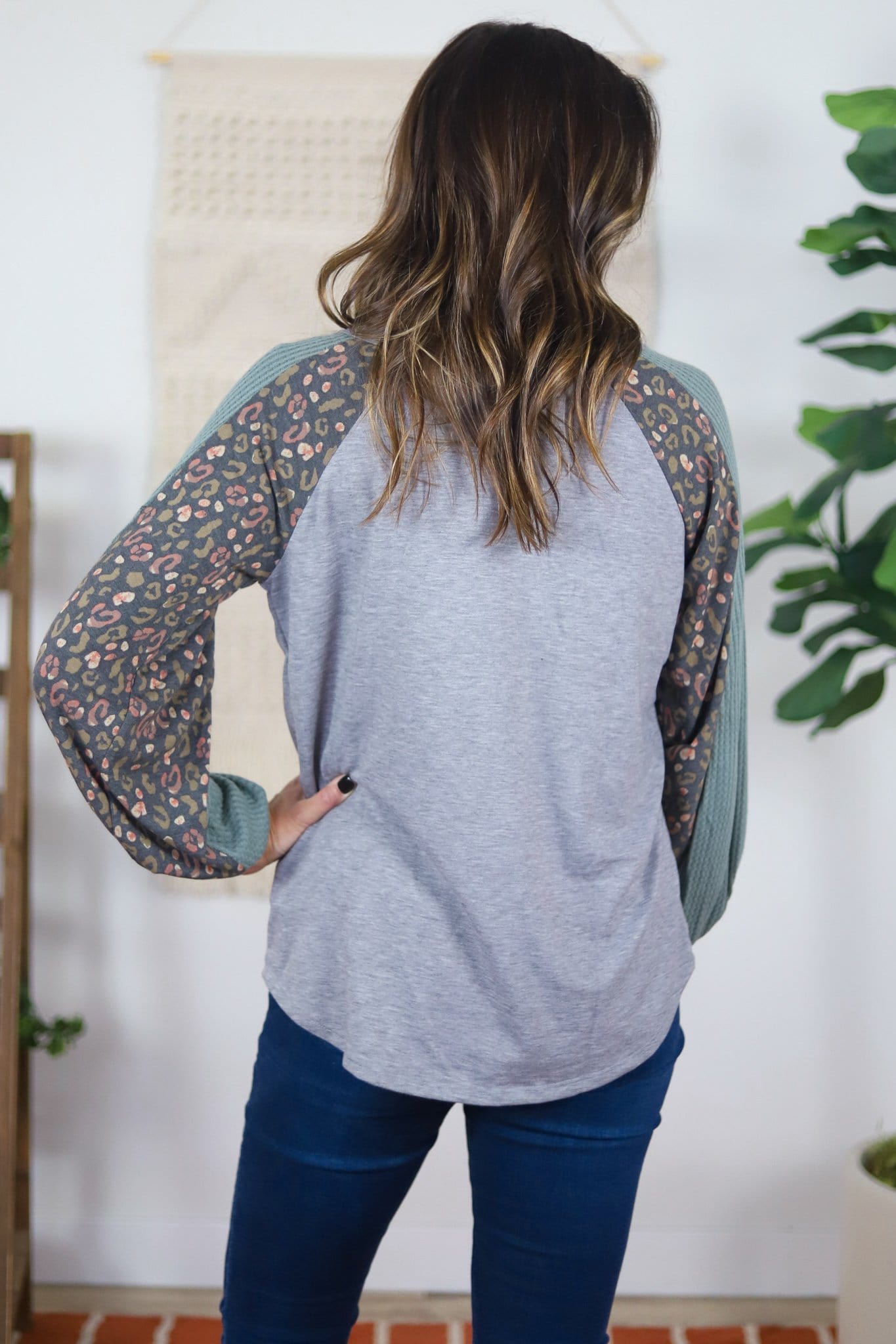 back of grey top with colored textured and patterned sleeves