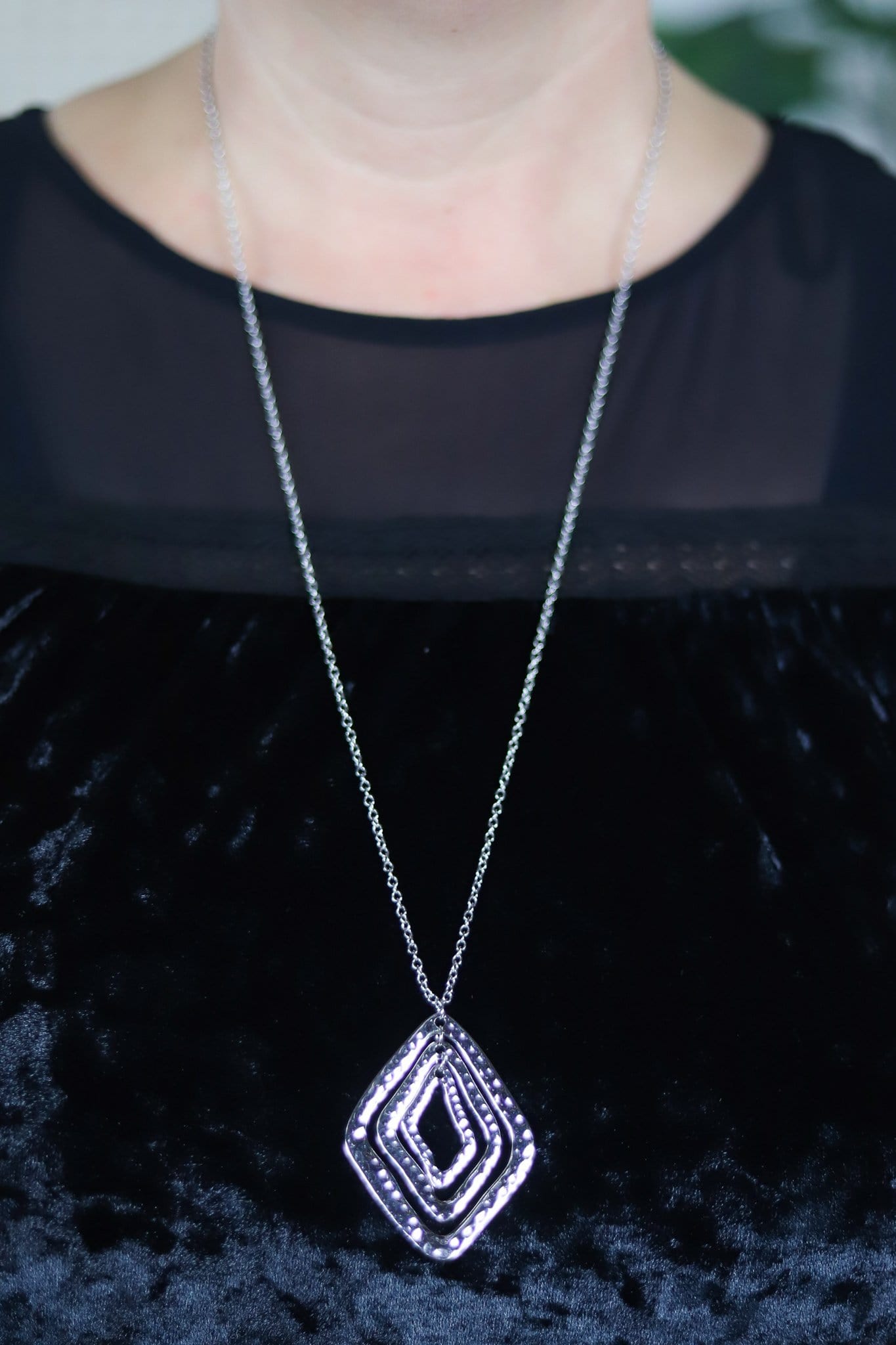 three silver diamonds on a silver chain necklace