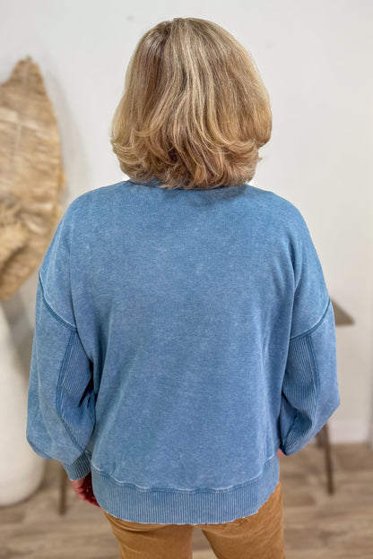 Person wearing a blue sweater with a neutral background